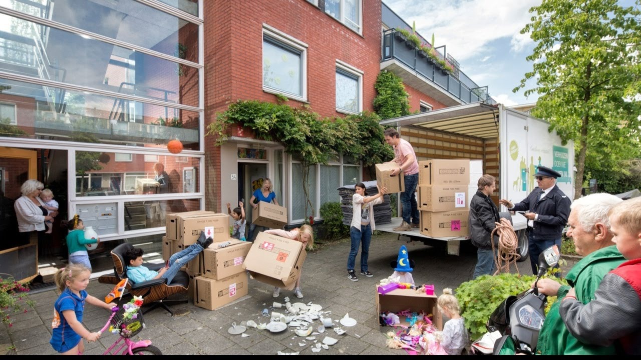 Verhuizers en familie laden samen de verhuiswagen van Verhuizen doen we Samen