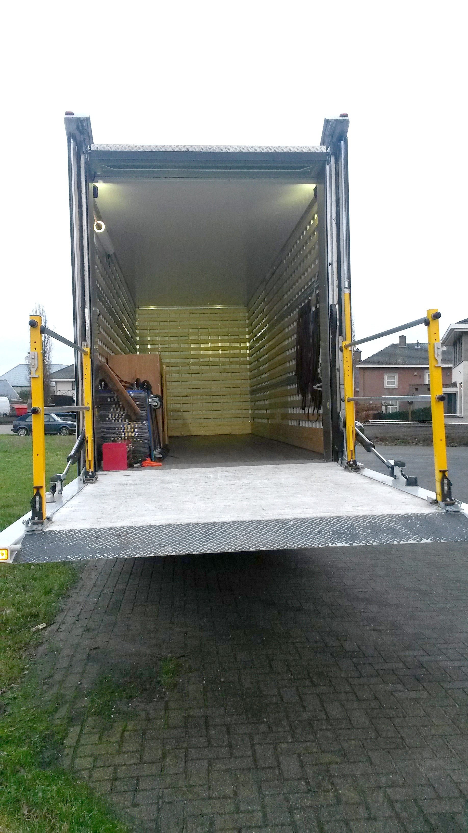 Geopende laadklep en laadruimte van de vrachtwagen
