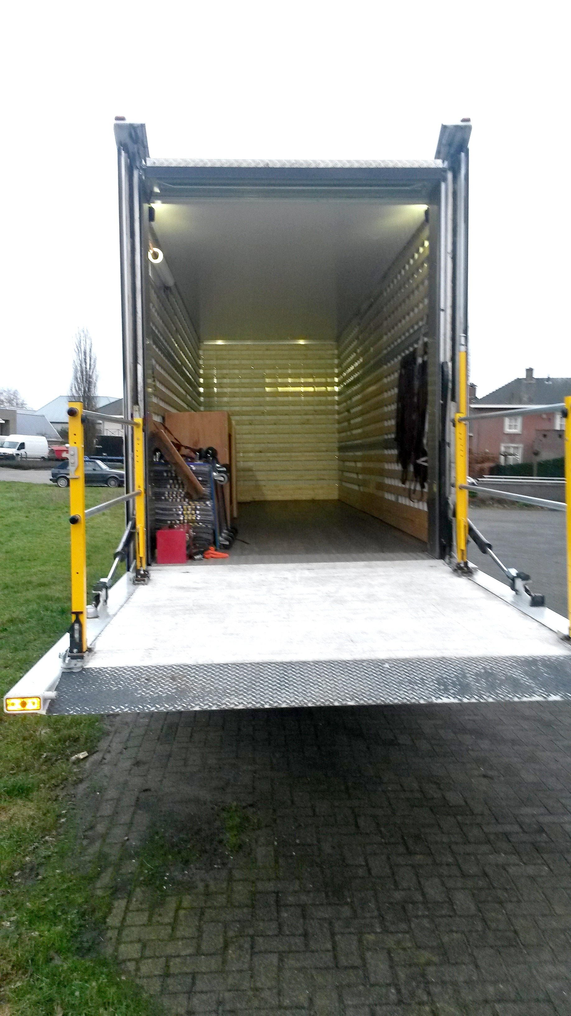 Ruime lege laadruimte met houten wanden en laadklep